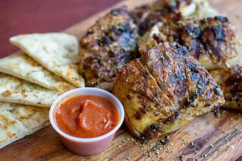 Grilled chicken with pita and a cup of red sauce