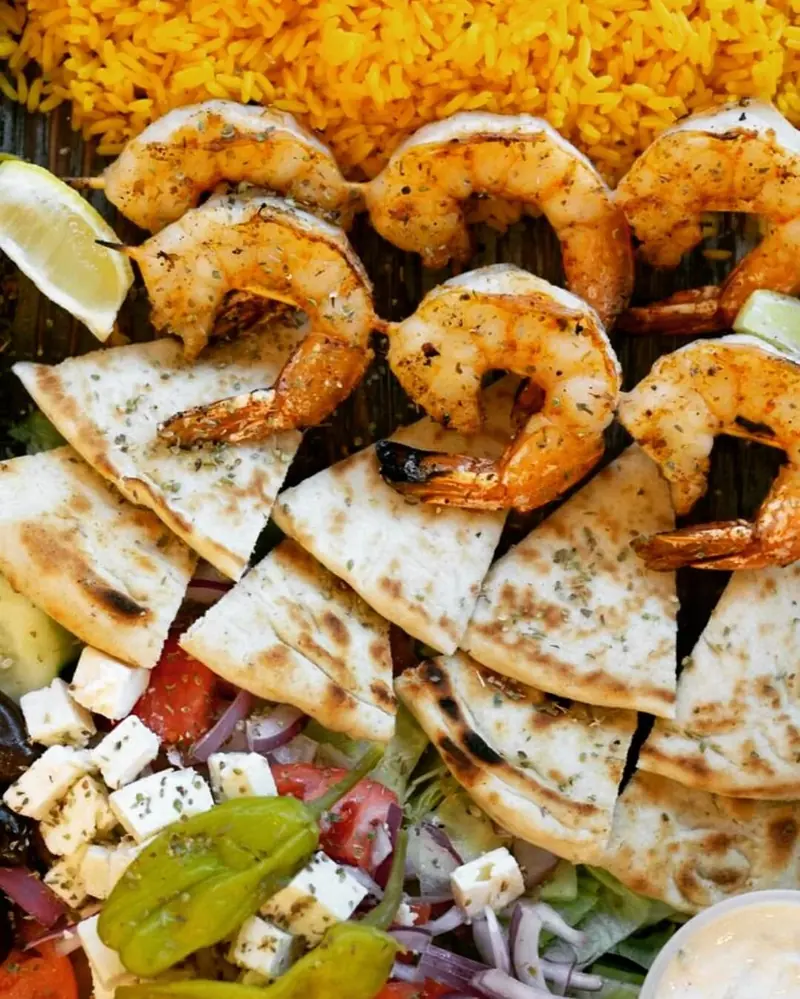 Grilled shrimp on pita wedges with feta and Greek salad
