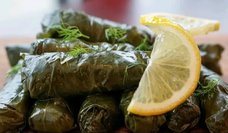 Stuffed grape leaves with a lemon wedge and dill