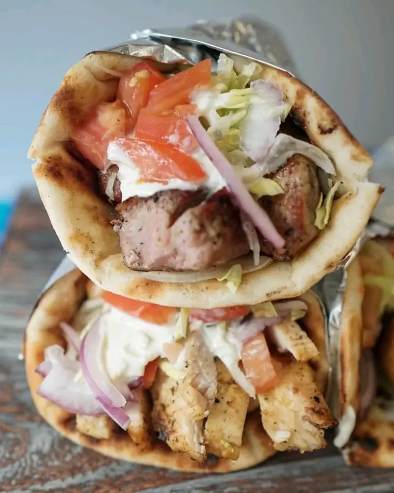 Two gyro pitas stacked, one with pork and one with chicken