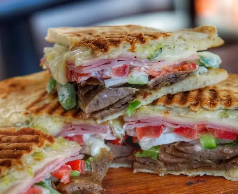 Pressed sandwich of gyro meat, ham, tomato and pepper
