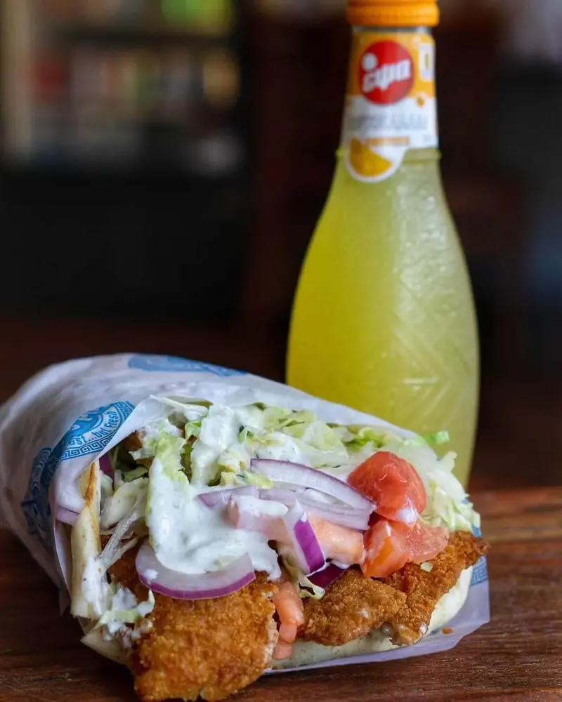 Falafel wrap beside a bottle of lemon soda