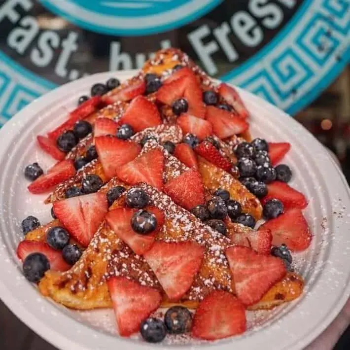 Berry-topped French toast on a plate printed with the Teddy's Place seal