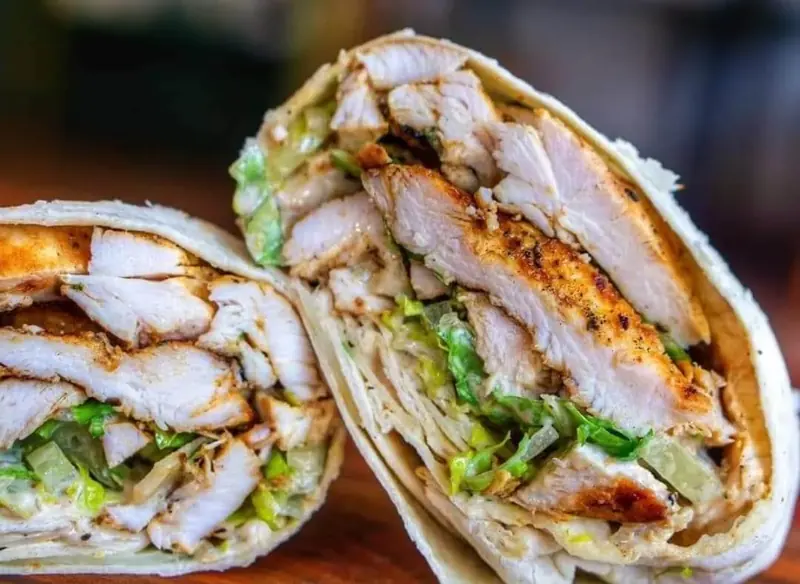 Sliced grilled chicken wrap with lettuce