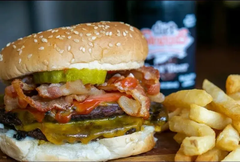 Bacon cheeseburger with pickle and fries