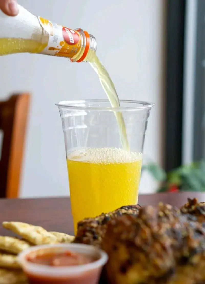 Orange soda pouring into a cup