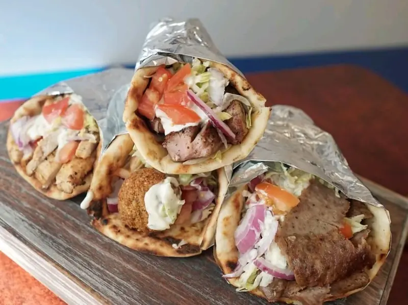 Three pitas wrapped in foil: gyro and falafel