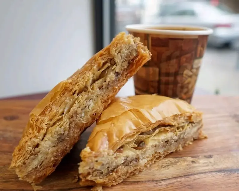 Flaky baklava beside a coffee