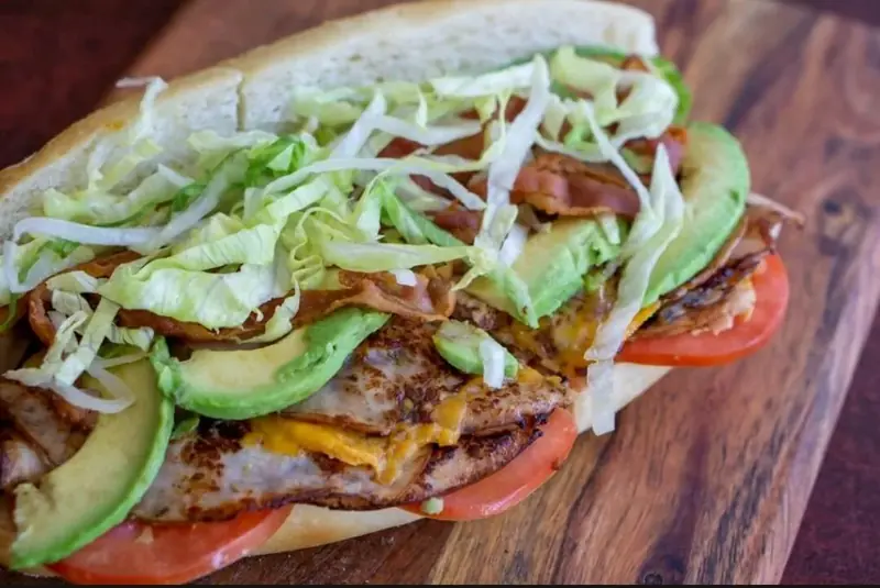 Sub with shredded lettuce, avocado, tomato and bacon