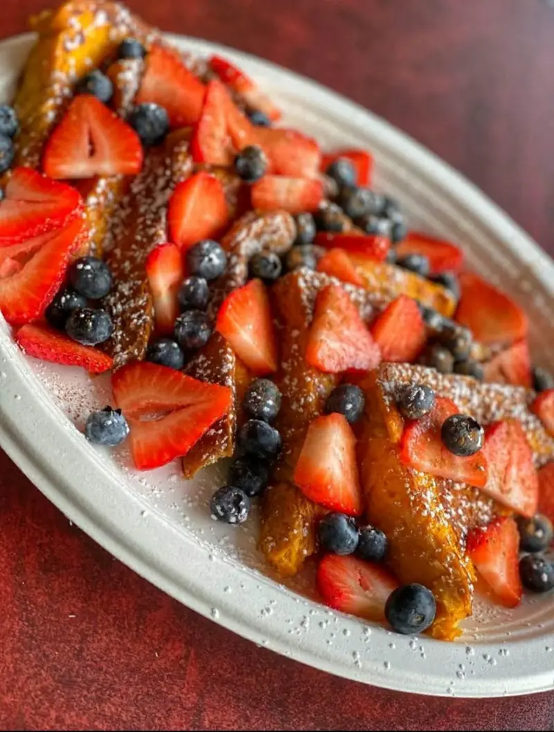 French toast piled with strawberries and blueberries
